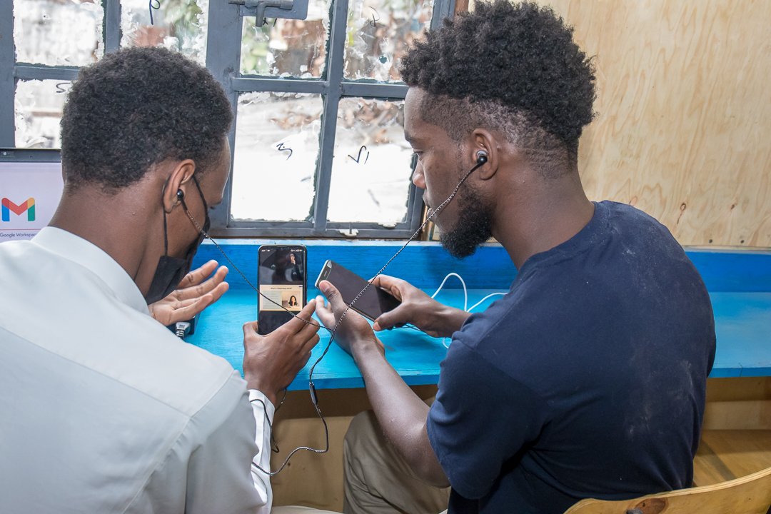 Zwei junge Männer nehmen an einem online Kurs in Mathare teil